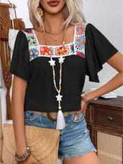 Black embroidered square neck blouse with flutter sleeves and colorful floral detail.