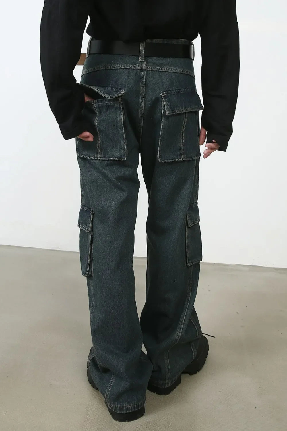 Panelled dark denim cargo pants with multiple utility pockets and a relaxed fit.