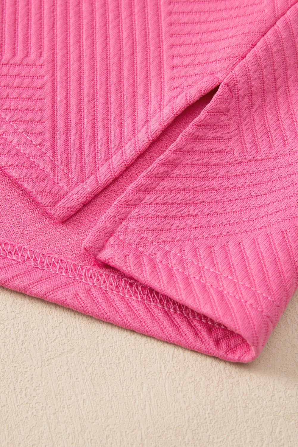 Hot pink quilted knit loungewear set detail with side slit and textured pattern.