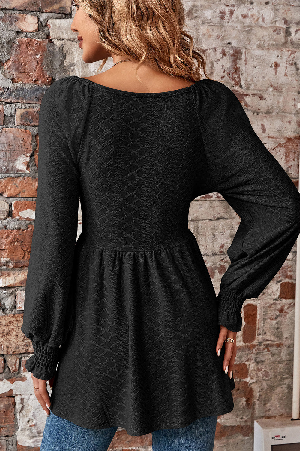 Black textured blouse with shirred empire waist and long shirred sleeves.