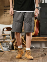 Men's gray drawstring shorts relaxed fit with cargo pockets and contrast stitching.