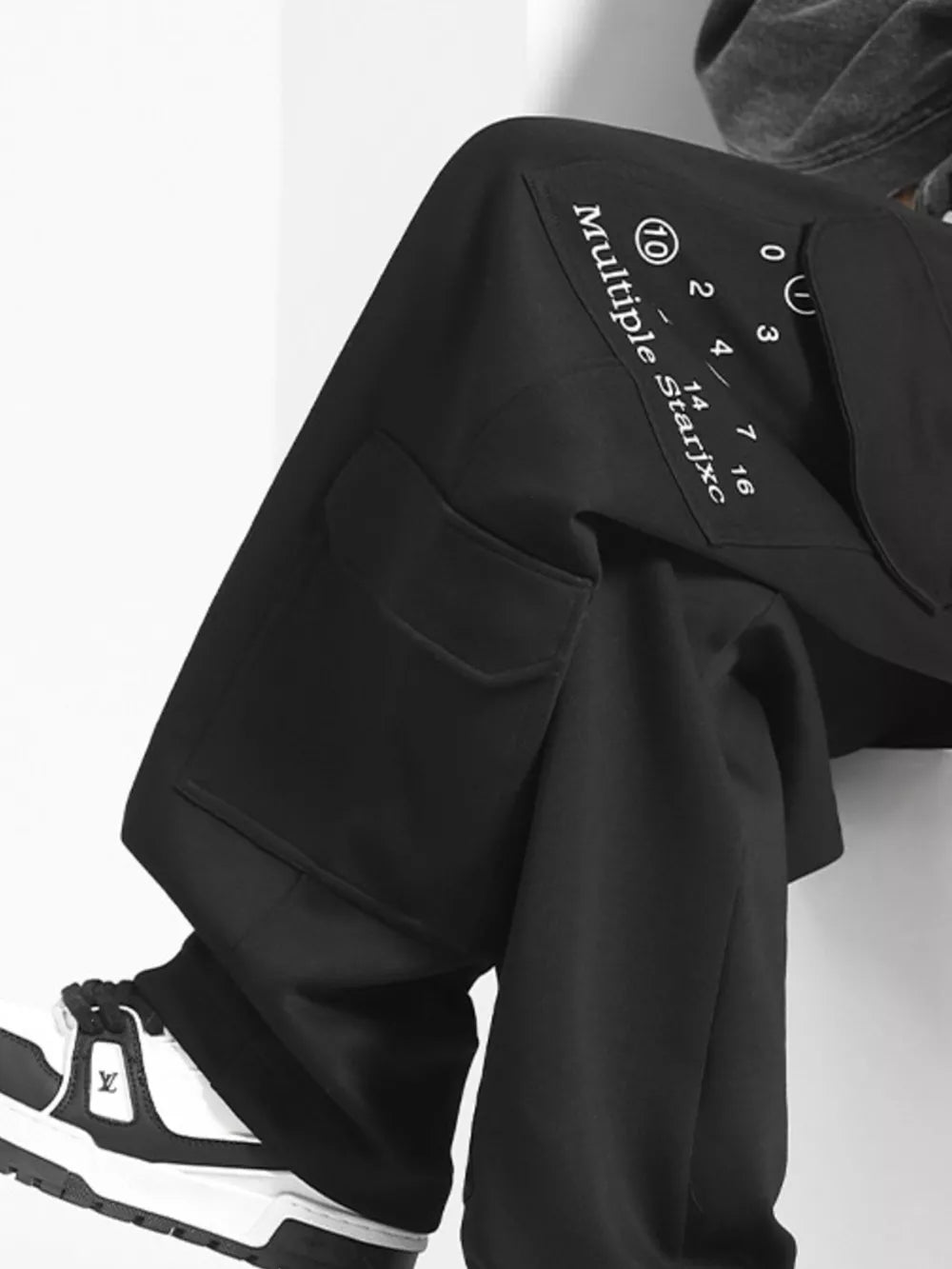 Black cargo sweatpants with drawstring and graphic text detail.