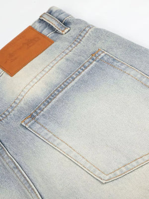 Men's vintage wash wide leg jeans in light blue denim with a brown leather patch.