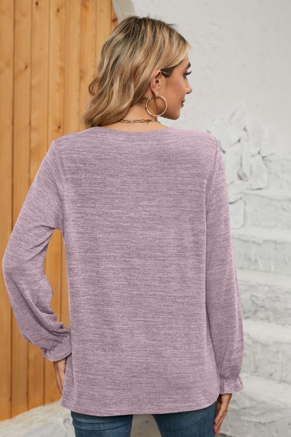 Lilac knit top with ruffled cuffs and a pleated yoke detail.