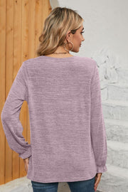 Lilac knit top with ruffled cuffs and a pleated yoke detail.