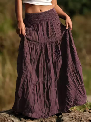 Burgundy tiered maxi skirt with smocked waist and flowing silhouette.