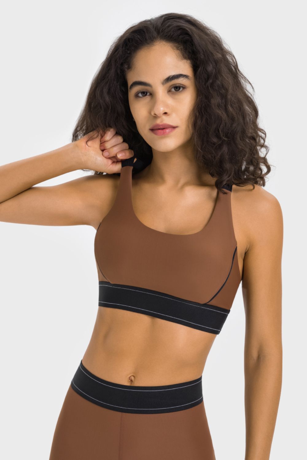 Performance sports bra in chocolate brown with black band and white stitching detail