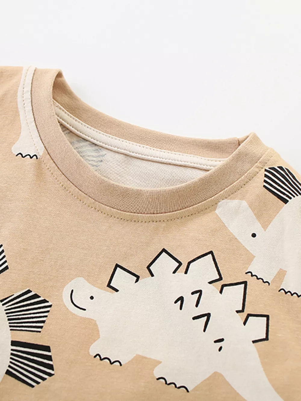 Beige cotton toddler t-shirt with a playful dinosaur print and crew neck.