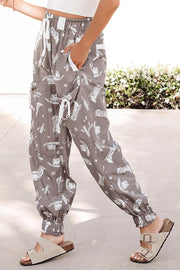 Grey cotton joggers with white western print, drawstring waist, and cuffed ankles.