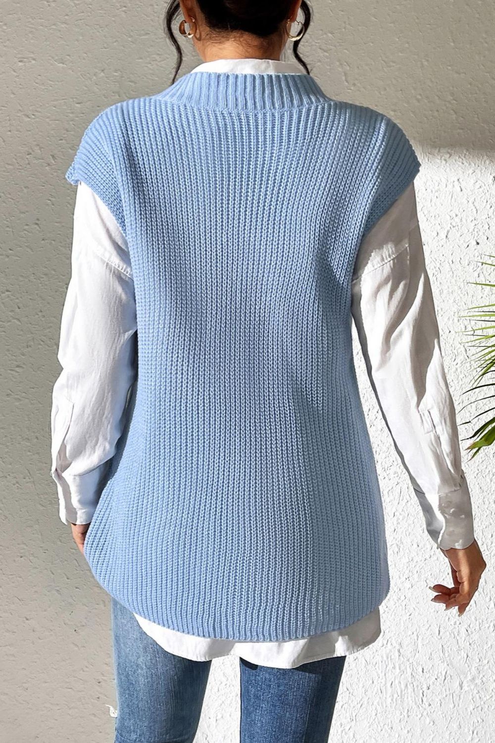 Light blue textured knit V-neck sleeveless top over a white button-down shirt.
