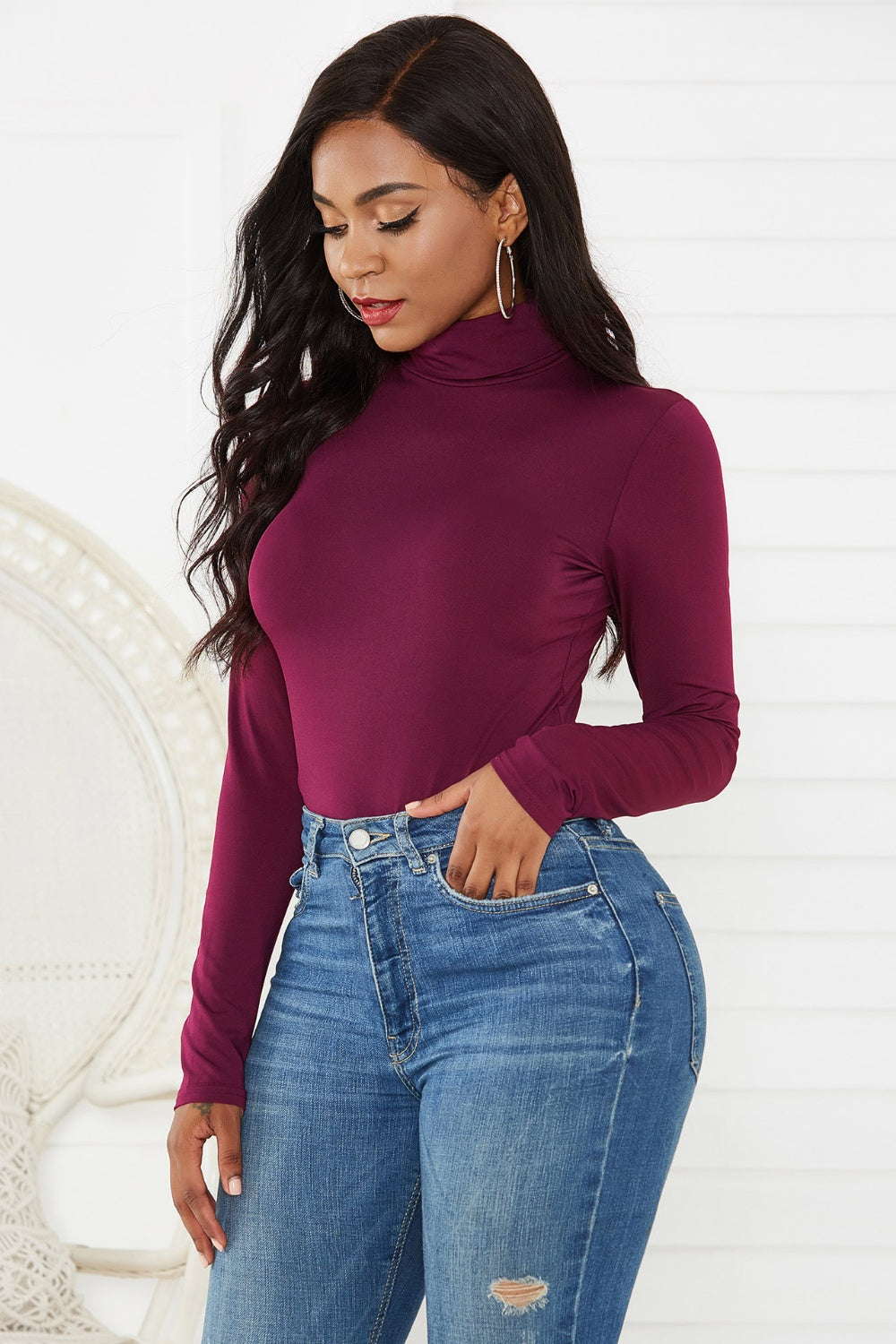 Burgundy turtleneck bodysuit with long sleeves, styled with jeans.