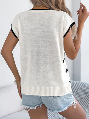 White cable knit sleeveless top with black trim and diamond pattern detail