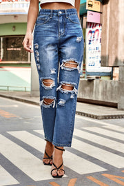 Distressed straight leg denim jeans in medium wash with ripped details.