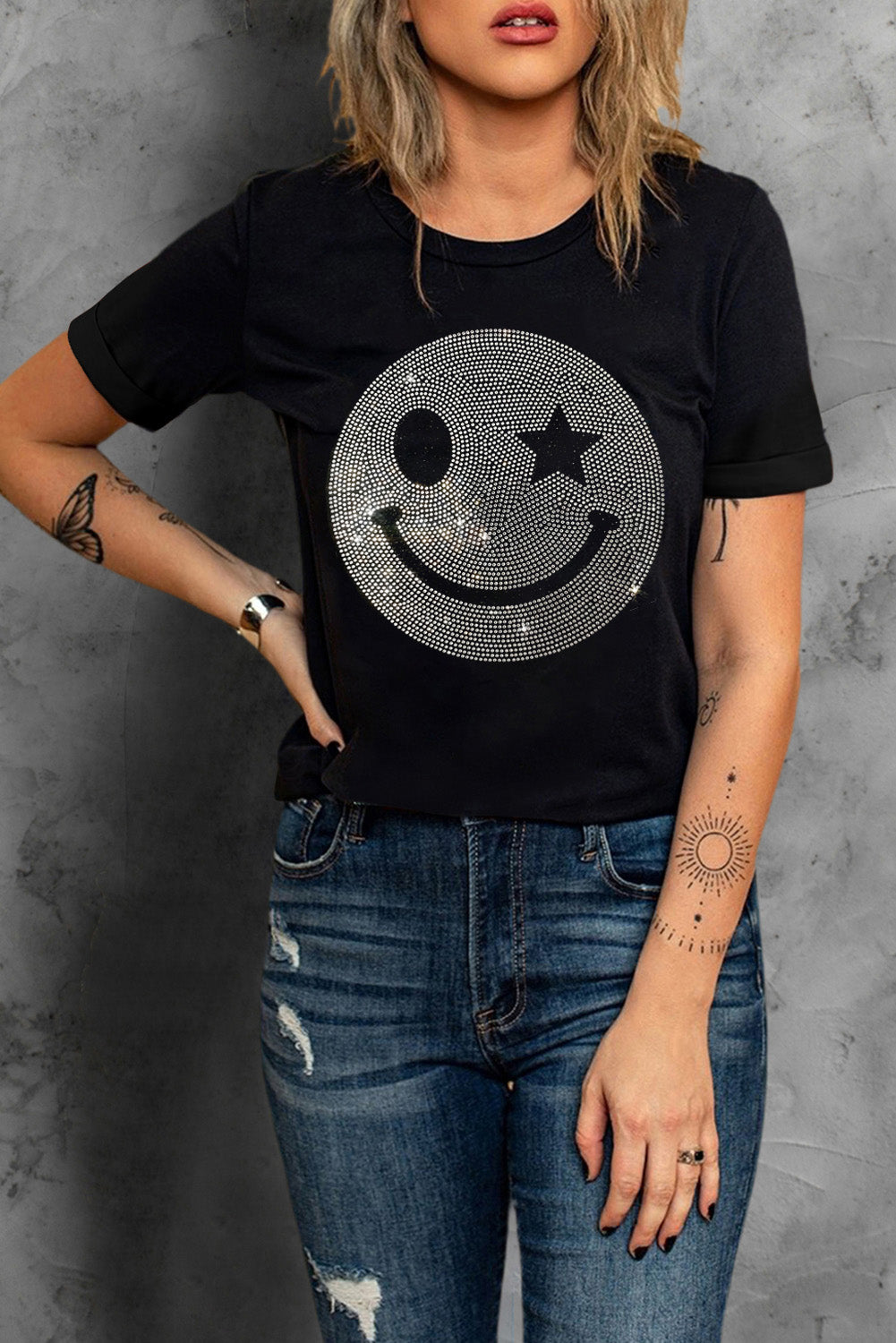 Black t-shirt with rhinestone smiley face graphic and rolled sleeves.
