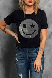 Black t-shirt with rhinestone smiley face graphic and rolled sleeves.