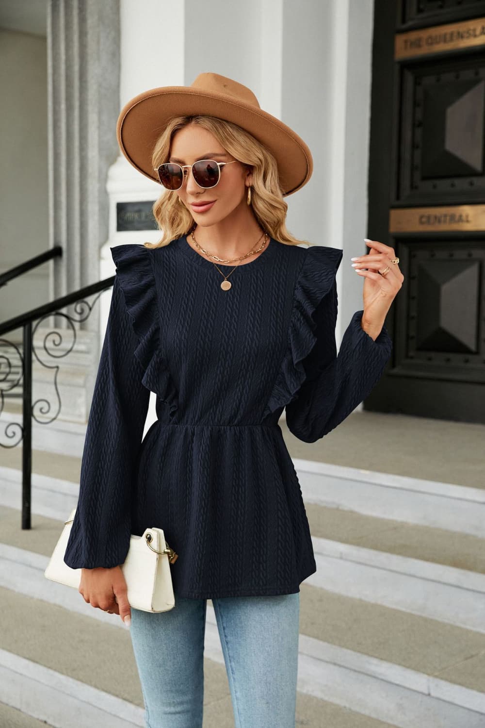 Navy textured ruffle peplum blouse with long sleeves and cinched waist.