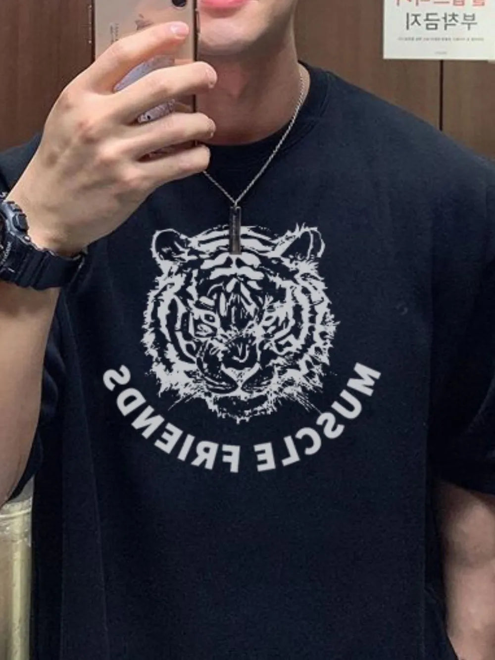 Black oversized tee with a white tiger graphic and curved text.