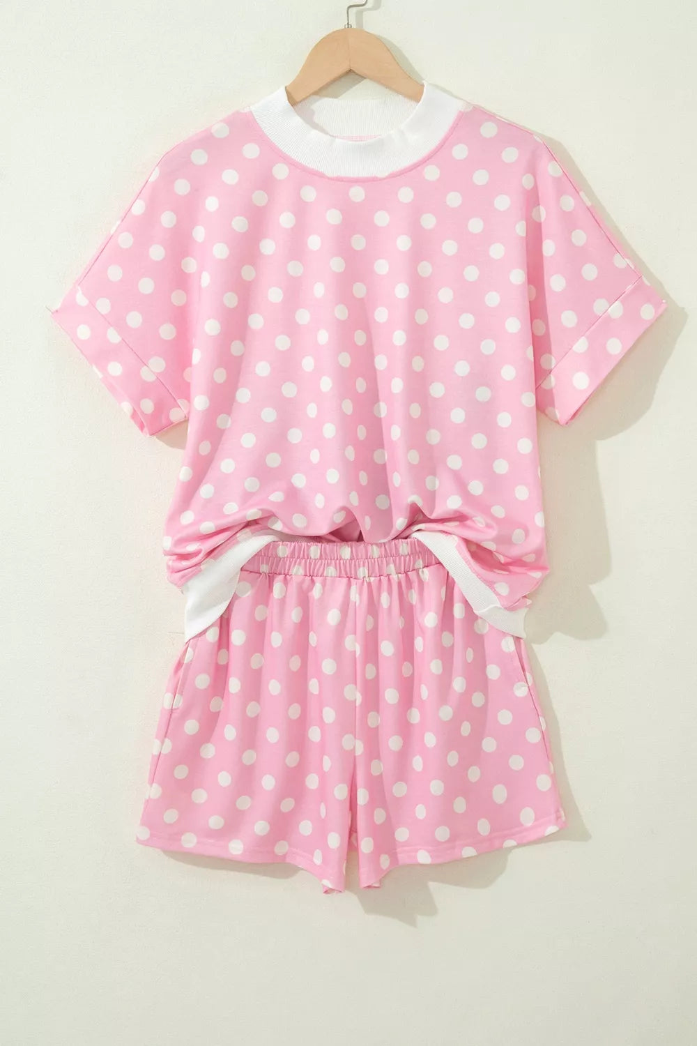 Pink polka dot polyester top and shorts set with white trim.