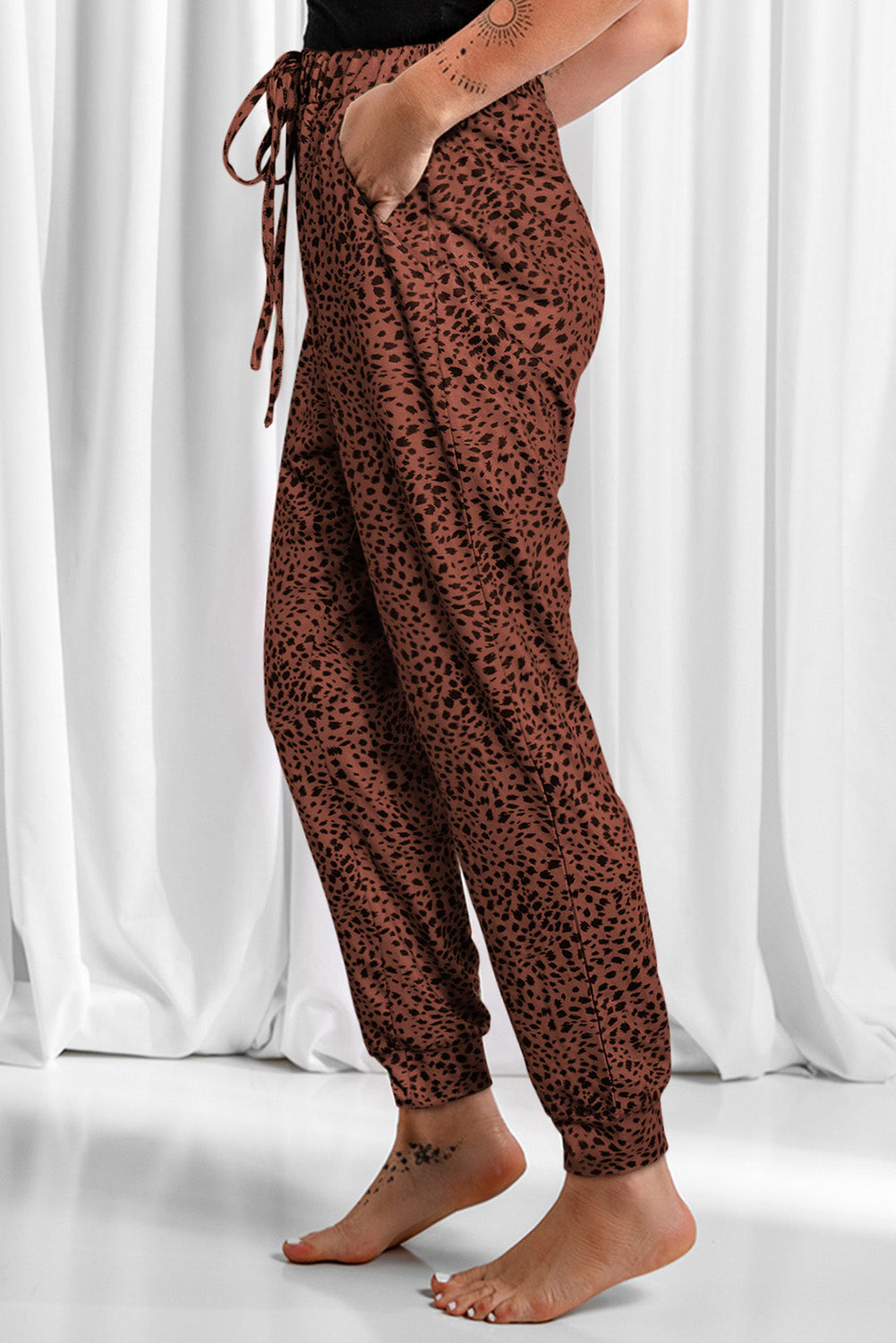 Brown leopard print joggers with drawstring waist and cuffed ankles.
