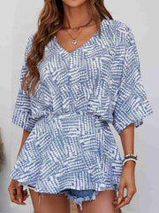 Light blue abstract print cinched waist blouse with V-neck and short sleeves.