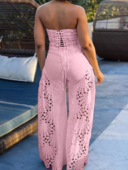 Pink strapless two-piece outfit with corset lace-up back and intricate openwork wide-leg pants.