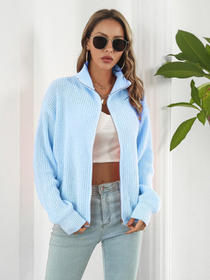 Pastel blue ribbed knit zip-up sweater with a mock neck and long sleeves.