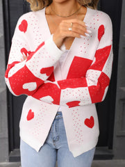 White and red heart motif acrylic cardigan with V-neck and long sleeves.
