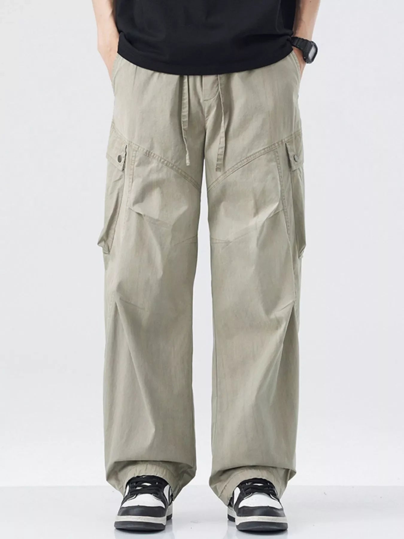 Loose fit khaki cargo pants with drawstring waist and multiple pockets.