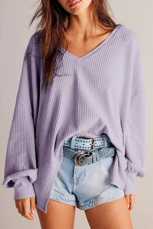 Lavender waffle knit blouson sleeve top with V-neck and cuffed sleeves.