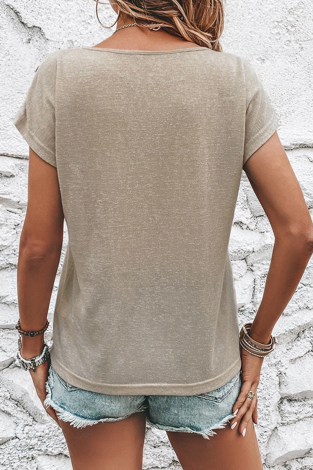 Khaki t-shirt with button shoulder detail and short sleeves.