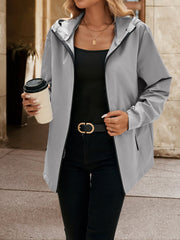 Gray zip-through hooded jacket with black trim, worn open over a black tank top.