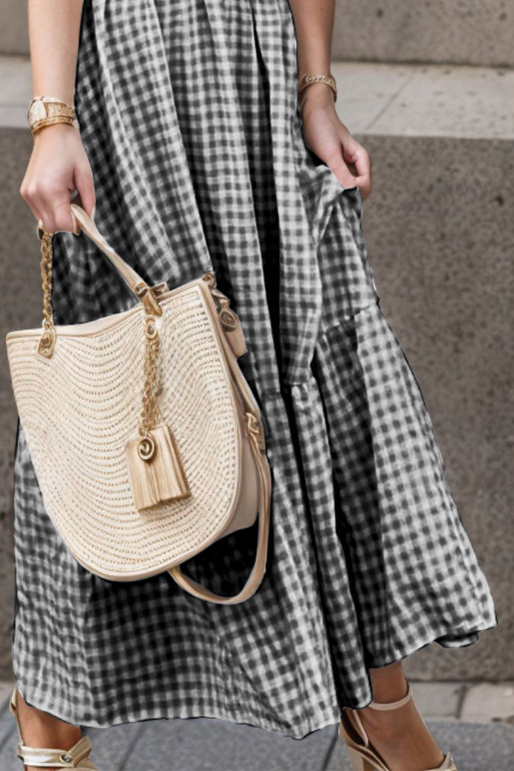 Black gingham maxi dress with smocked bodice and flutter sleeves, styled with a straw bag.