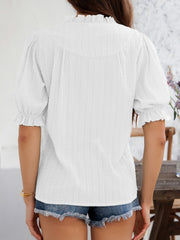 White textured puff sleeve blouse with ruffled neckline and cuffs.