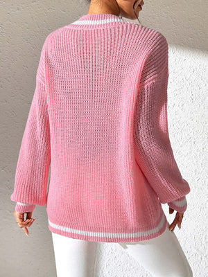Dusty pink knit sweater with white striped V-neck and hem, long sleeves.