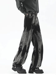 Men's black relaxed fit jeans with acid wash detail and studded belt.