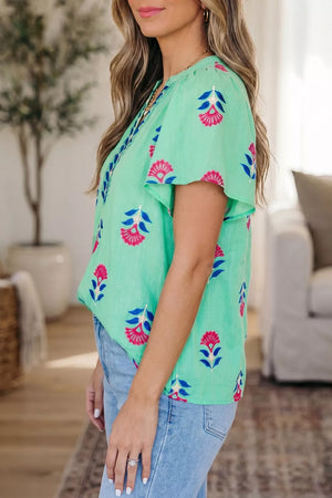 Embroidered floral V-neck flutter sleeve blouse in light green with pink and blue floral print.