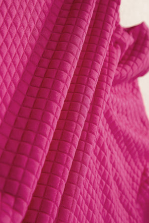 Hot Pink quilted knit fabric with diamond pattern detail.