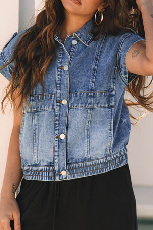 Boxy denim vest in medium wash with button front, chest pockets, and shoulder detail.