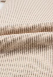 Beige ribbed knit sweater detail showing texture and fabric.