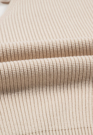 Beige ribbed knit sweater detail showing texture and fabric.