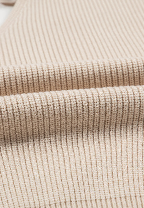Beige ribbed knit sweater detail showing texture and fabric.