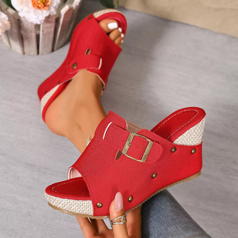 Red wedge sandals with decorative accents and buckle detail.