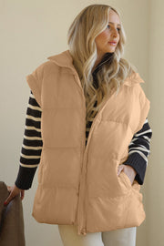 Tan padded sleeveless hooded vest with zip front and pockets, worn over striped sweater.