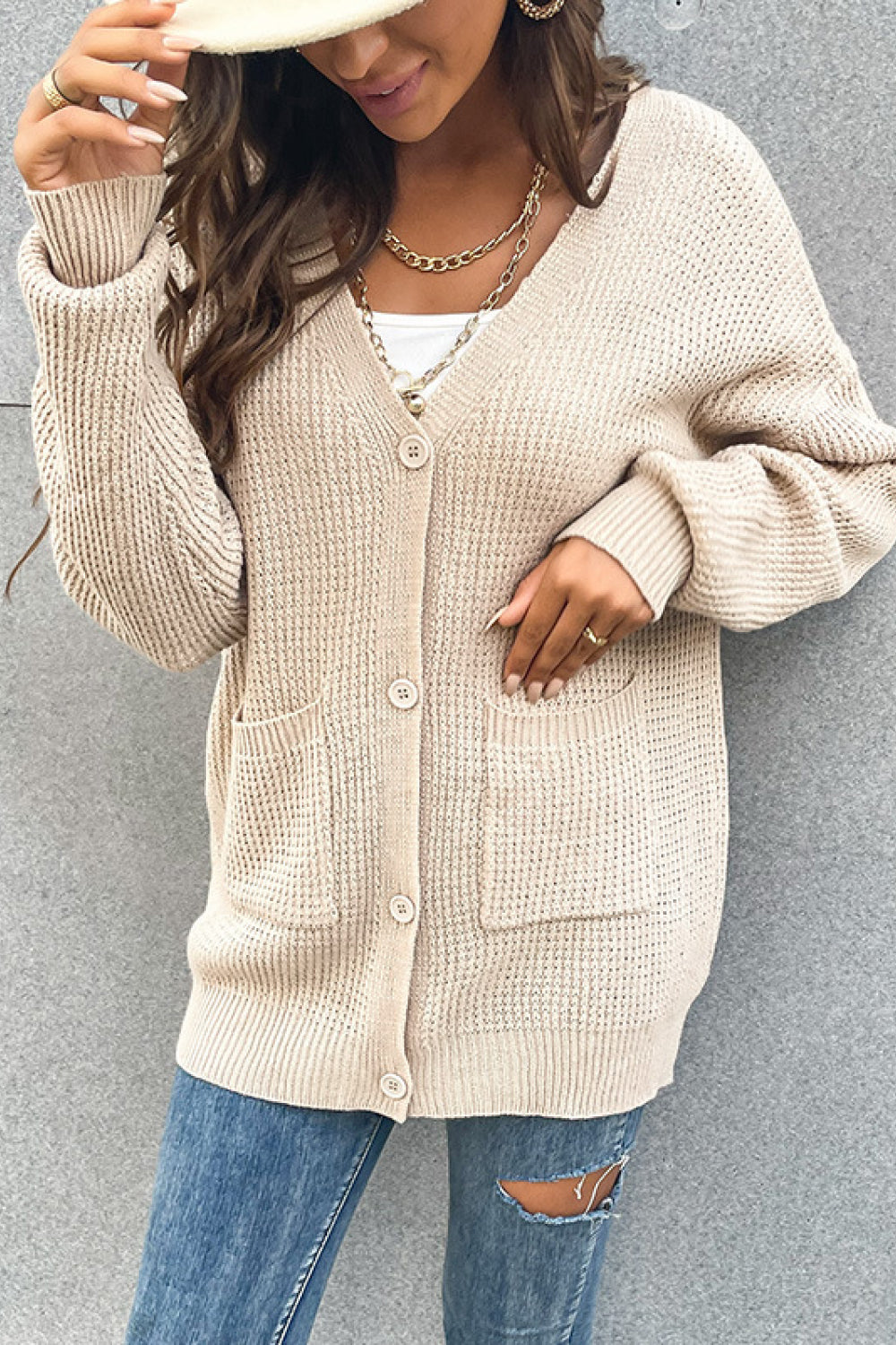 Beige waffle knit button cardigan with pockets and V-neck.