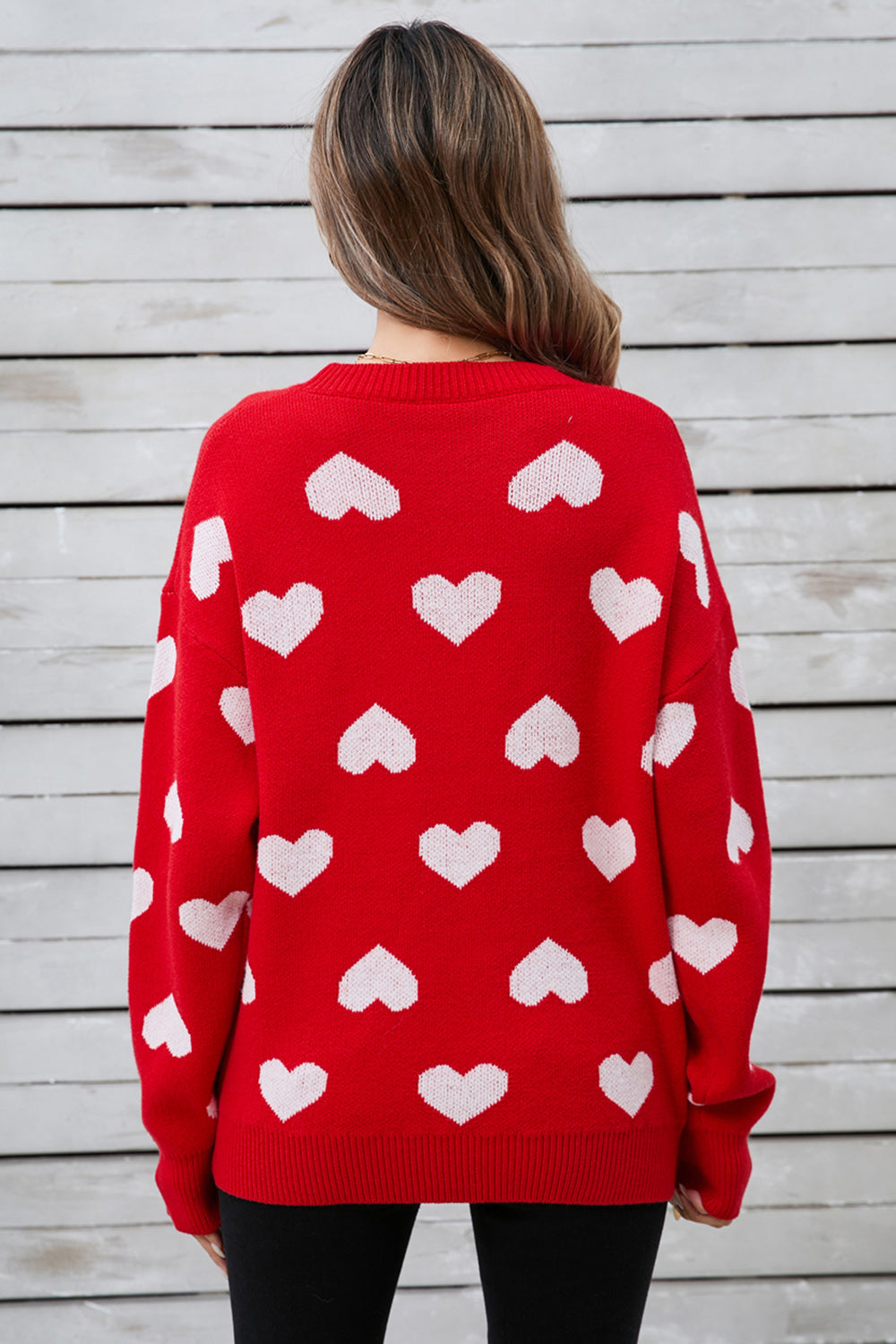Red acrylic sweater with allover white intarsia hearts pattern.