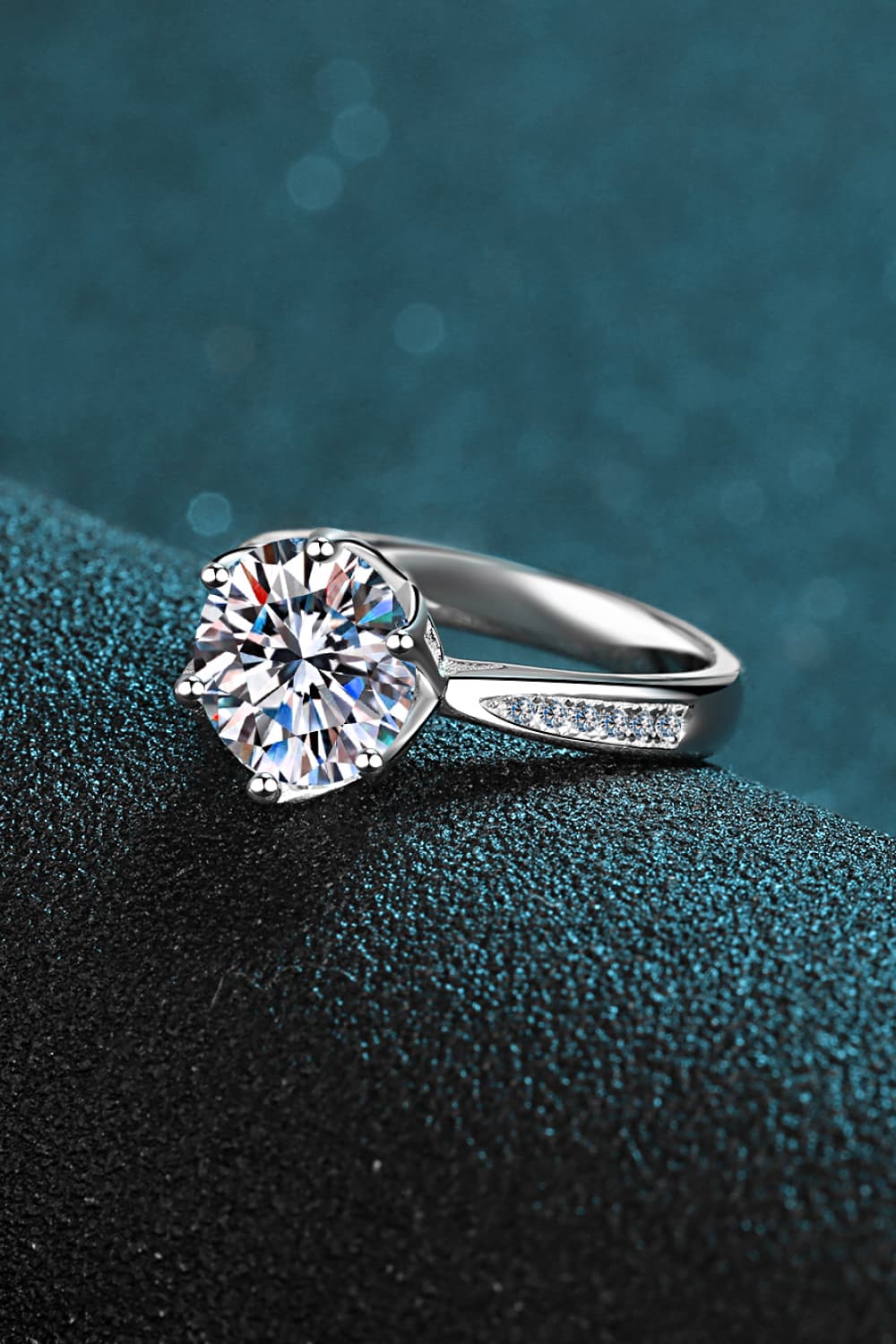 Silver ring with a large moissanite center stone and pavé band.