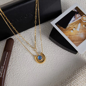 Gold-plated layered pendant necklace with blue stone and delicate chains