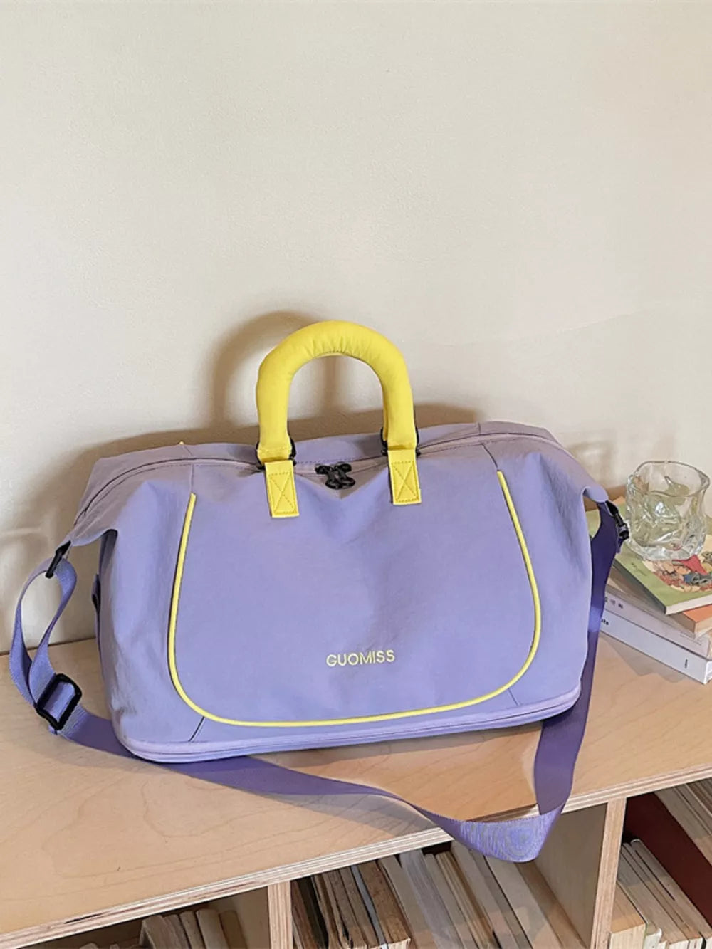 Purple Oxford cloth duffle bag with yellow trim and handles, featuring a crossbody strap.