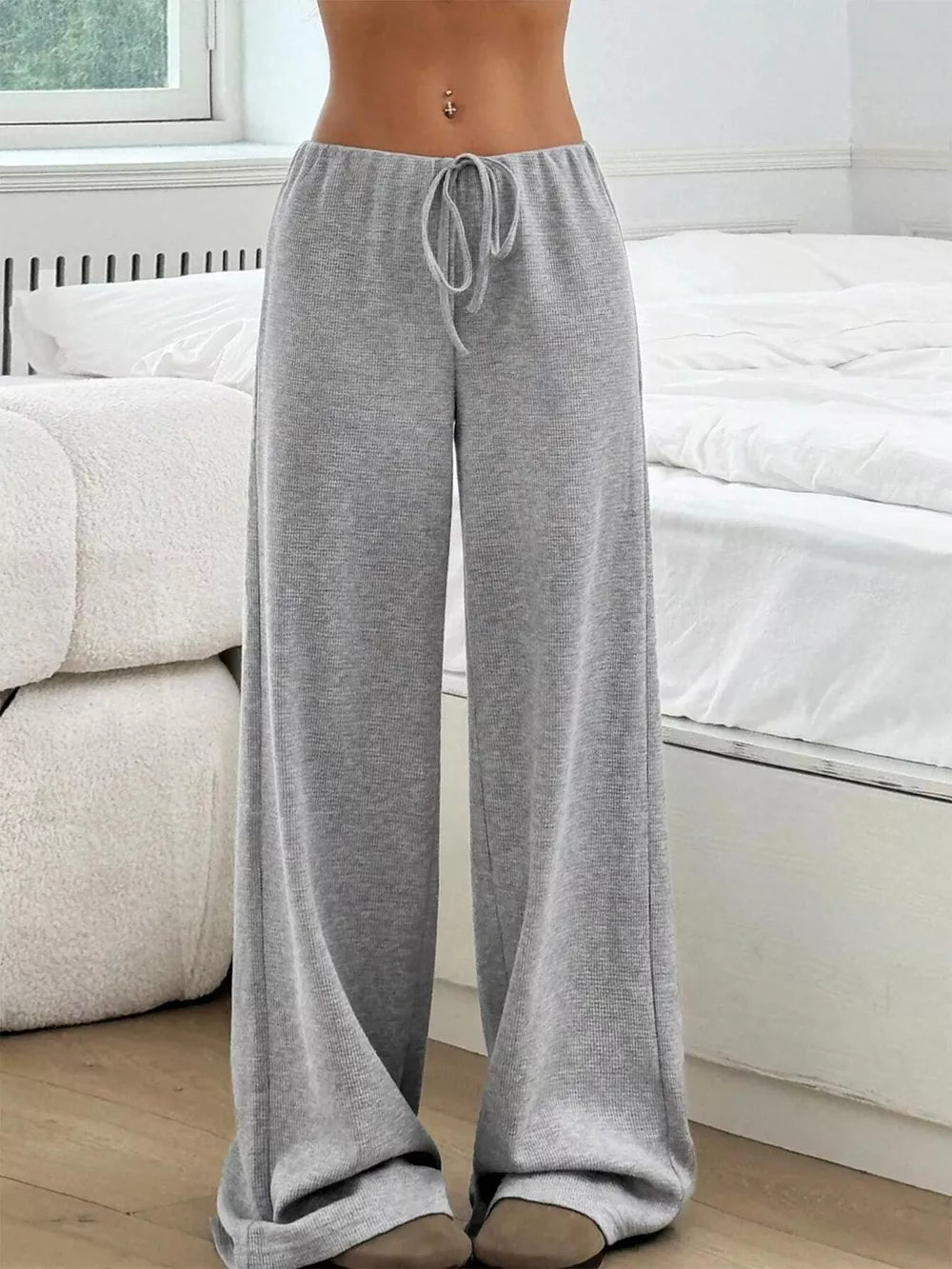 Light gray ribbed wide-leg pants with drawstring waist and a relaxed fit.