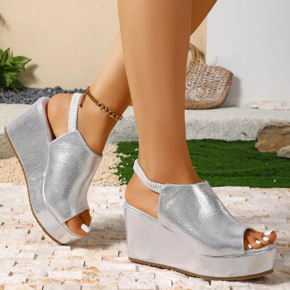 Sleek silver high heel wedge sandals with peep toe and elastic ankle strap.
